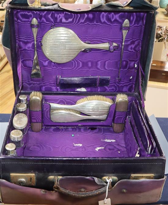 A George V travelling toilet case containing twelve matches silver mounted toilet jars etc.